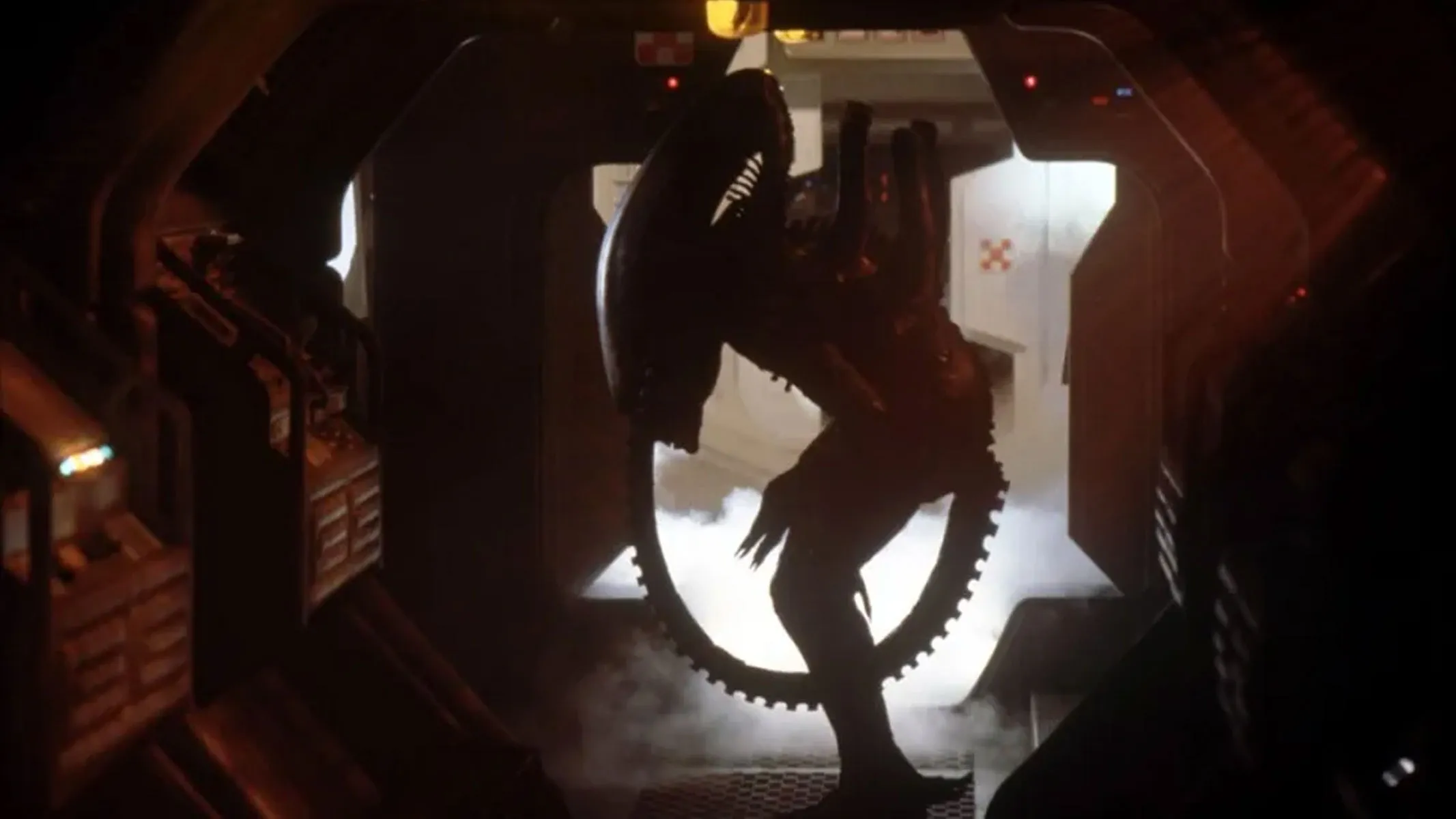 Ein schwarzer Alien-Xenomorph steht bedrohlich in einem metallischen Flur, aus dem Rauch/Dampf hinter ihm aufsteigt.